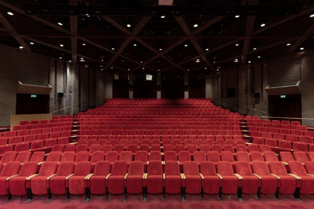 Rebecca Crown Hall auditorium viewed from the stage toward red audience seats