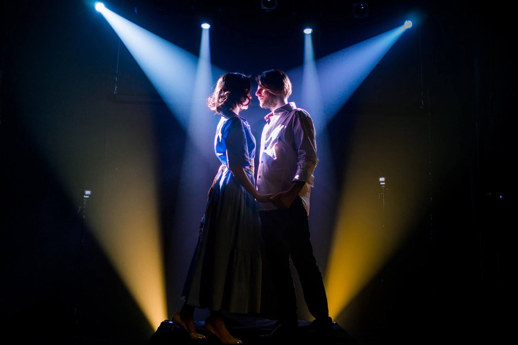 Two performers under crossing beams of light
